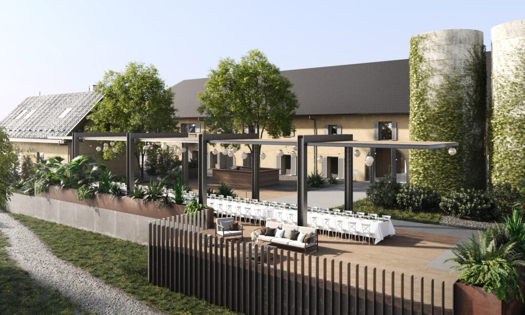 Charmante Outdoor-Hochzeitslocation in Österreich mit langen Esstischen, Lounge-Sitzgelegenheiten unter Bäumen und einem rustikalen, scheunenartigen Gebäude im Hintergrund - perfekt für Heiraten in Österreich.